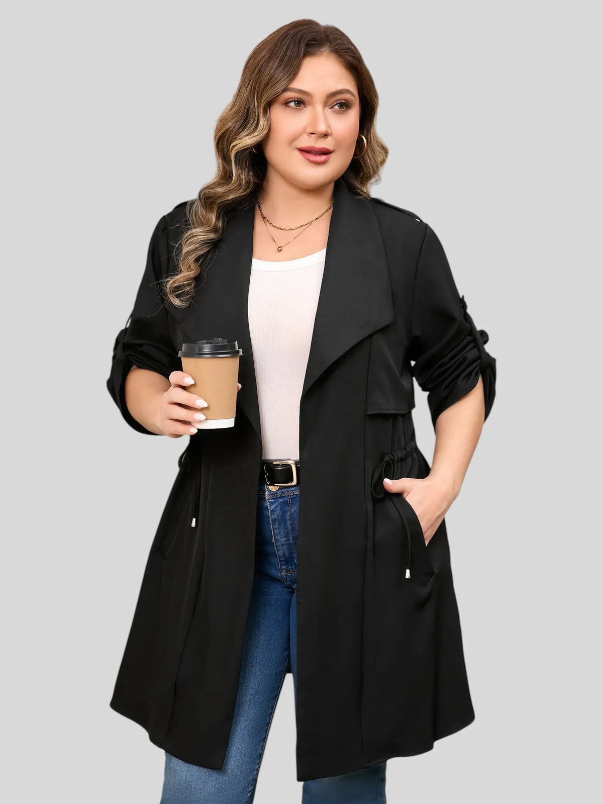 Drawstring-waist trench coat in black, front view with sleeves pushed up.