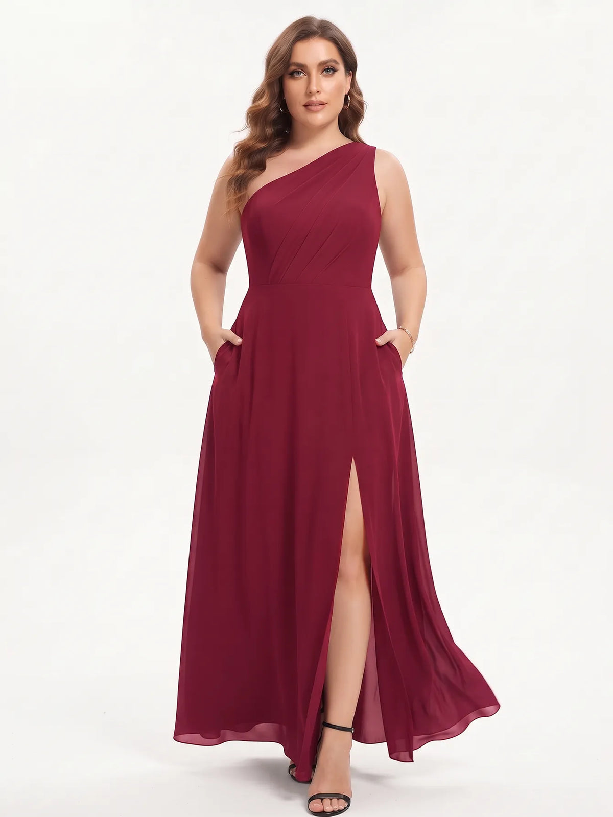 One-shoulder chiffon maxi dress in burgundy, front view with hands in the pockets.