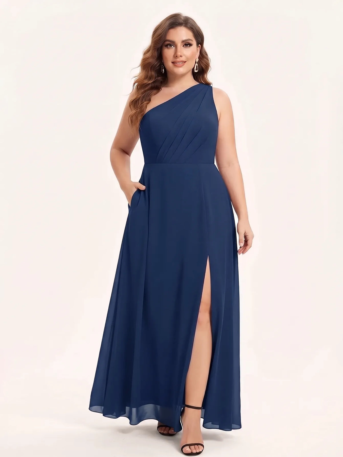 One-shoulder chiffon maxi dress in navy, front view with hands in the pockets.