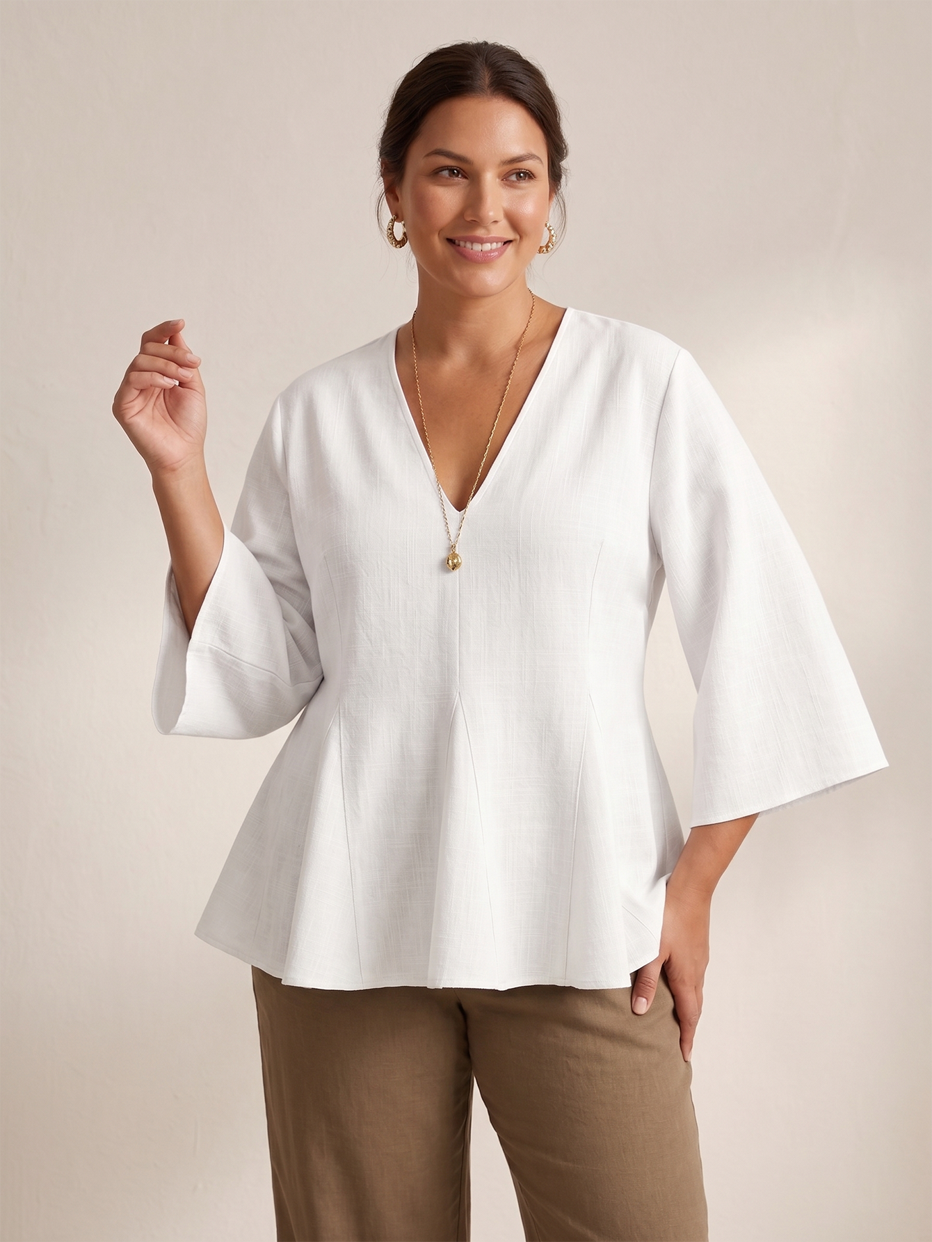 White linen-blend V-neck top with 3/4 sleeves and godet hem, front view.
