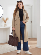Belted midi trench coat in beige, outfit shown indoors.
