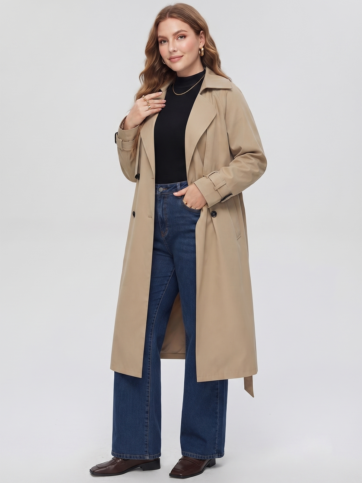 Belted midi trench coat in beige, worn open over a top and jeans.