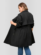 Drawstring-waist trench coat in black, back view.