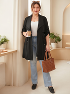 Drawstring-waist trench coat in black, styled with a handbag.