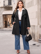 Drawstring-waist trench coat in black, styled with jeans outdoors.