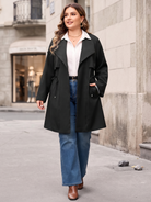 Drawstring-waist trench coat in black, styled with jeans outdoors.