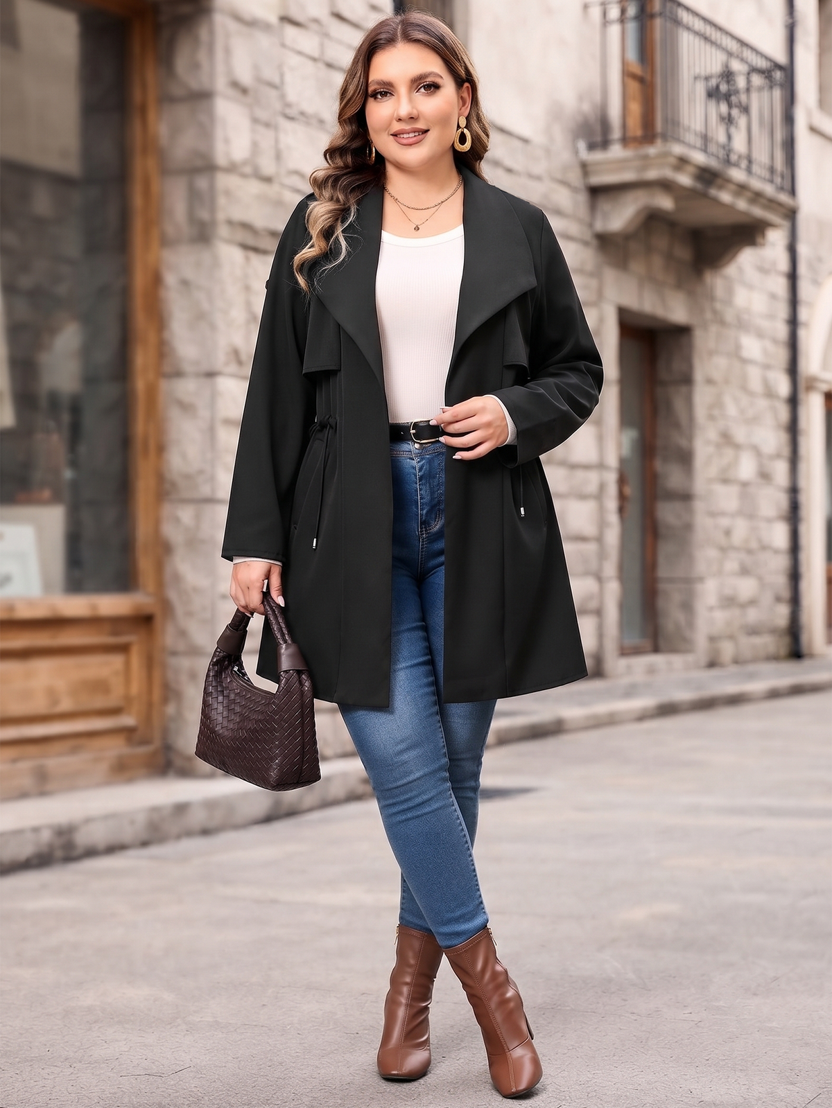 Drawstring-waist trench coat in black, walking view with jeans.