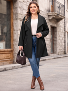 Drawstring-waist trench coat in black, walking view with jeans.