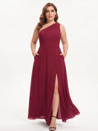 One-shoulder chiffon maxi dress in burgundy, front view with hands in the pockets.